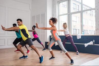 In the photo, there are four people in a dance studio simultaneously performing one of the dance steps.